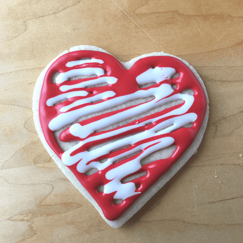 A heart sugar cookie with white and red icing