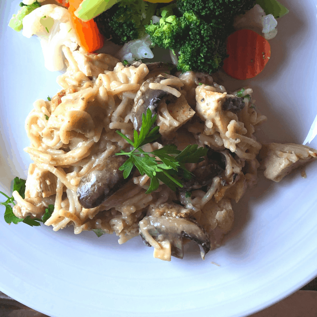 A plate with chicken tetrazzini and mixed vegetables