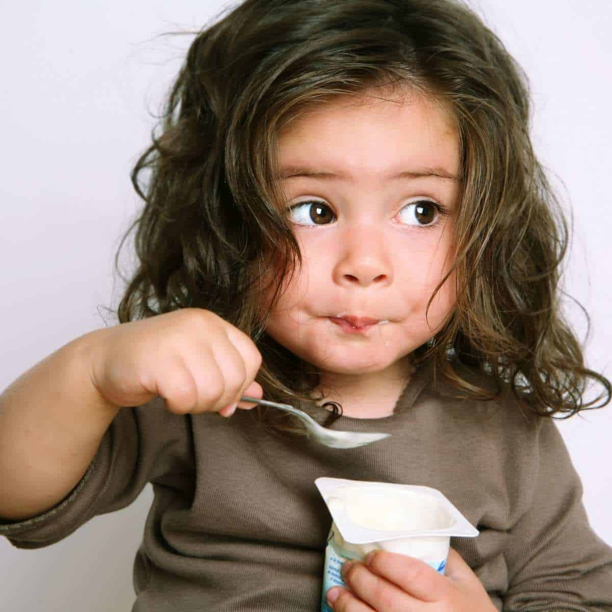 Child eating dairy yogurt with allergy free protein power added