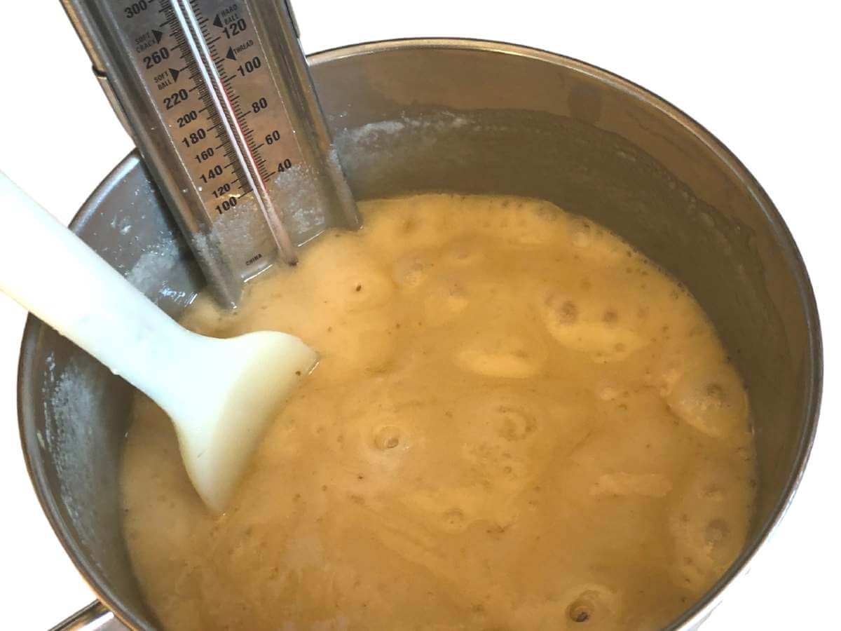 A mixture of sugar and milk boiling in a saucepan.