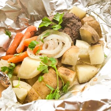 A hobo dinner hamburger foil pack with potatoes, carrots, and onions