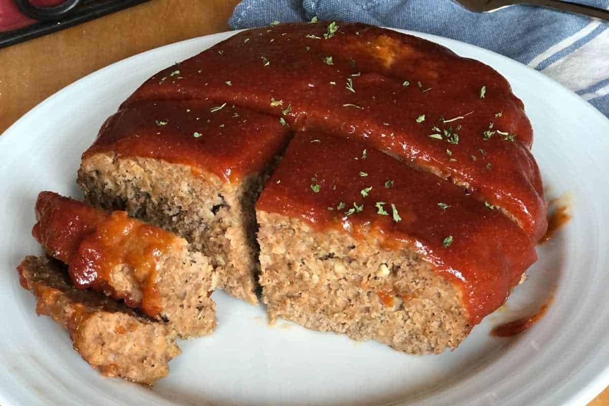 A platter with sliced eggless meatloaf on it.