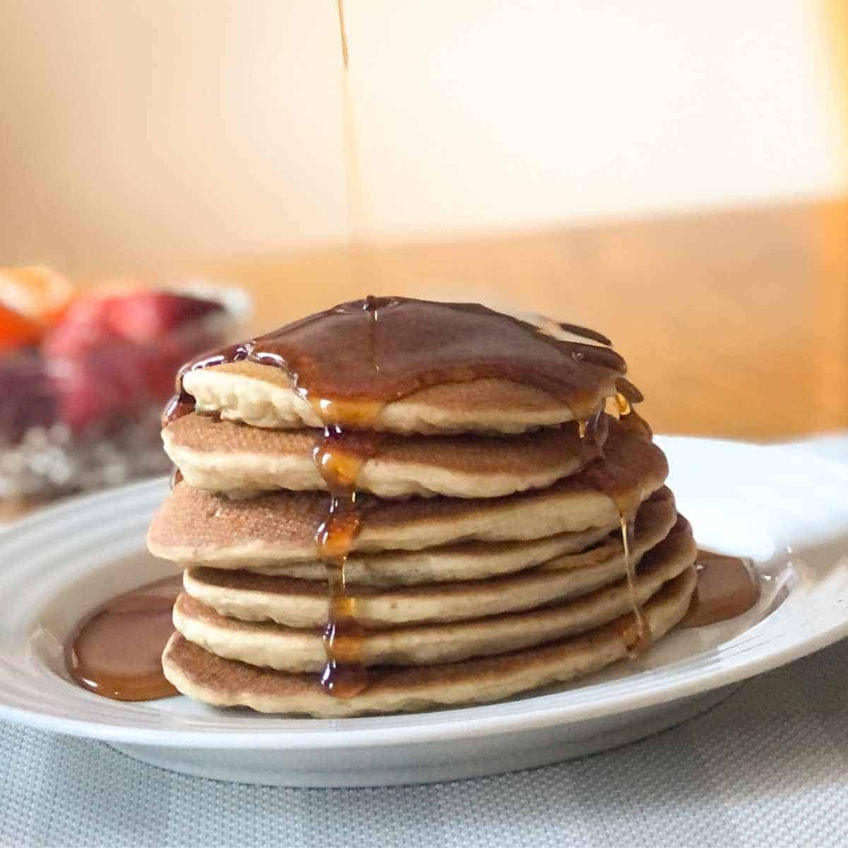 A stack of dairy free oat milk pancakes with maple syrup.