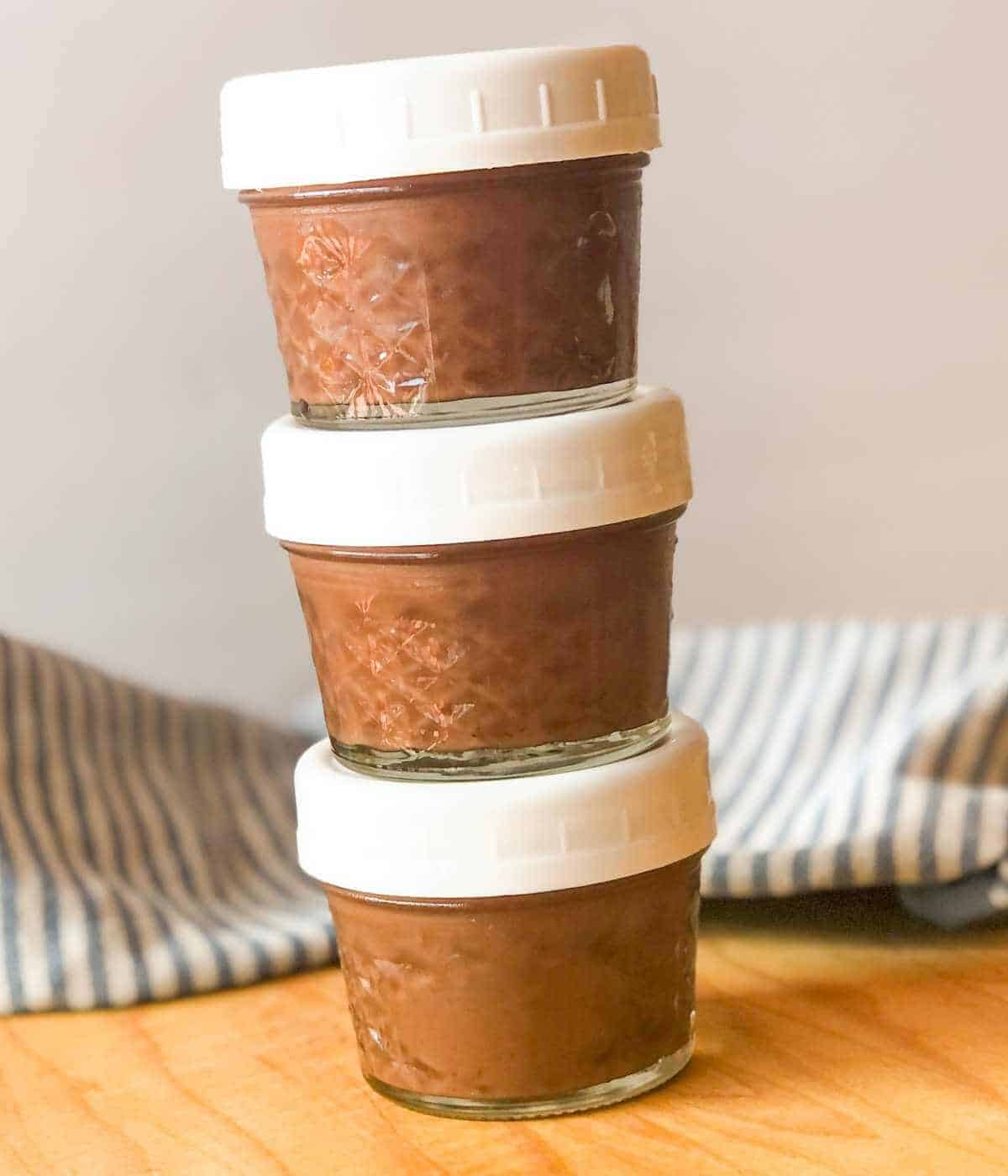 oat milk chocolate pudding in covered half-pint jars stacked