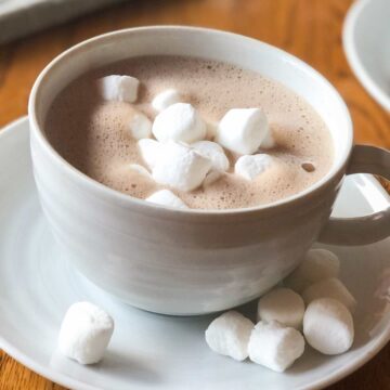 A cup of oat milk hot chocolate topped with marshmallows