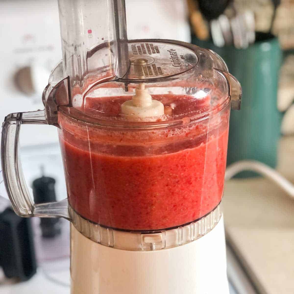 Pureed strawberry and sugar mixture in a food processor.