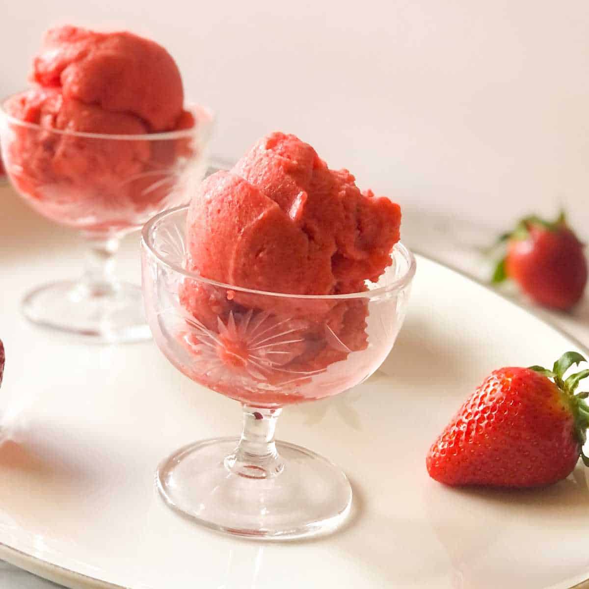 Dairy free sorbet with strawberries in a glass dish.