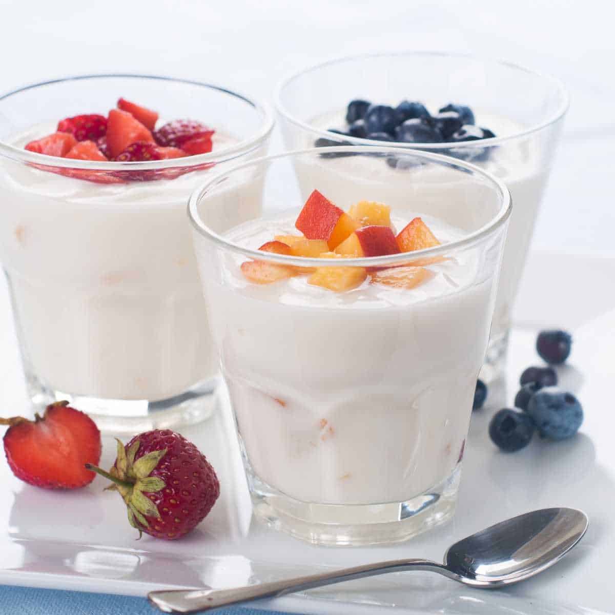 Three cups with dairy free yogurt topped with fruit.