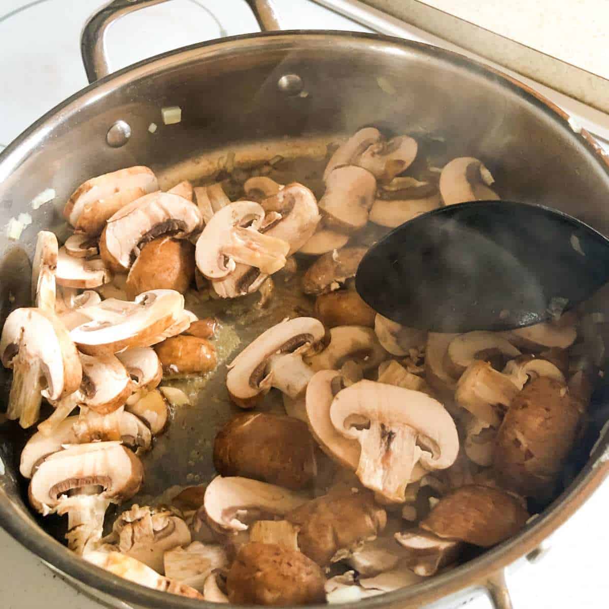Sliced mushrooms being sauteed in dairy free butter