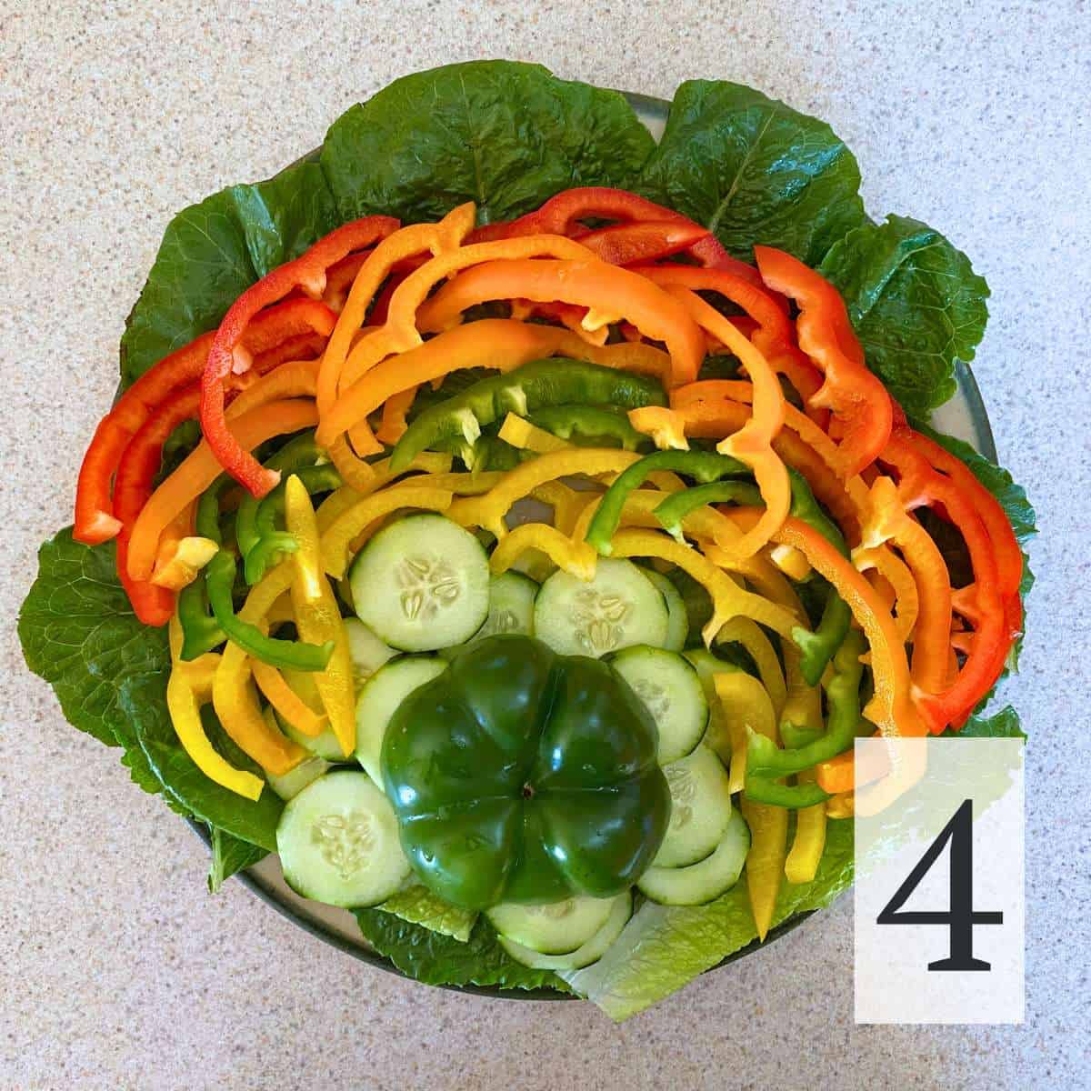 Step 4: bell peppers arranged around a mound of cucumbers and the bottom of a green pepper.