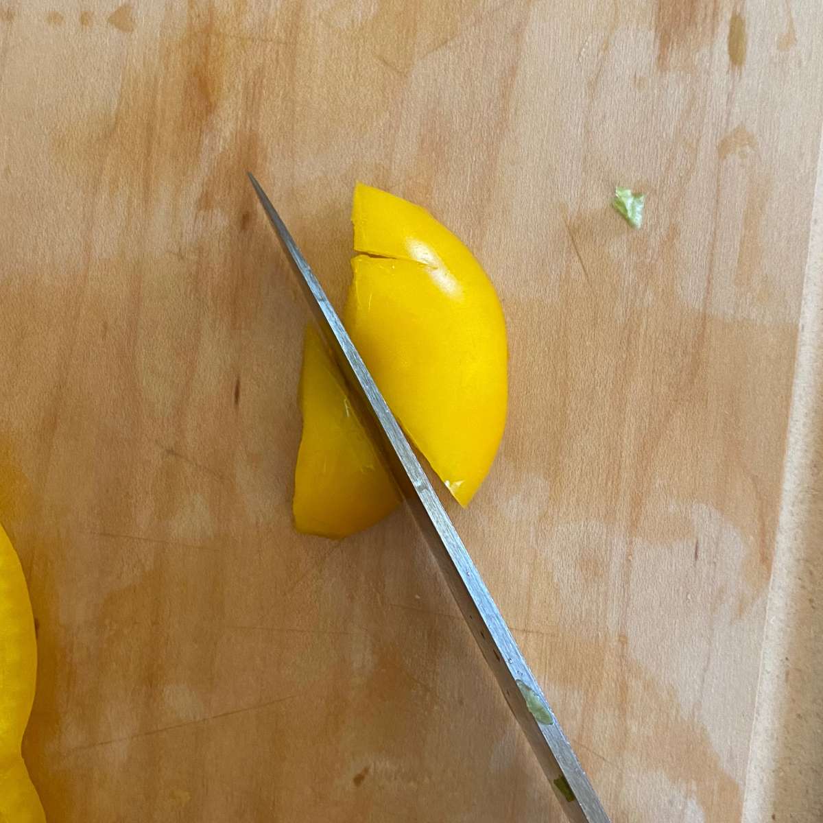 A section of the top of a yellow pepper being cut into a triangle for the turkey beak.