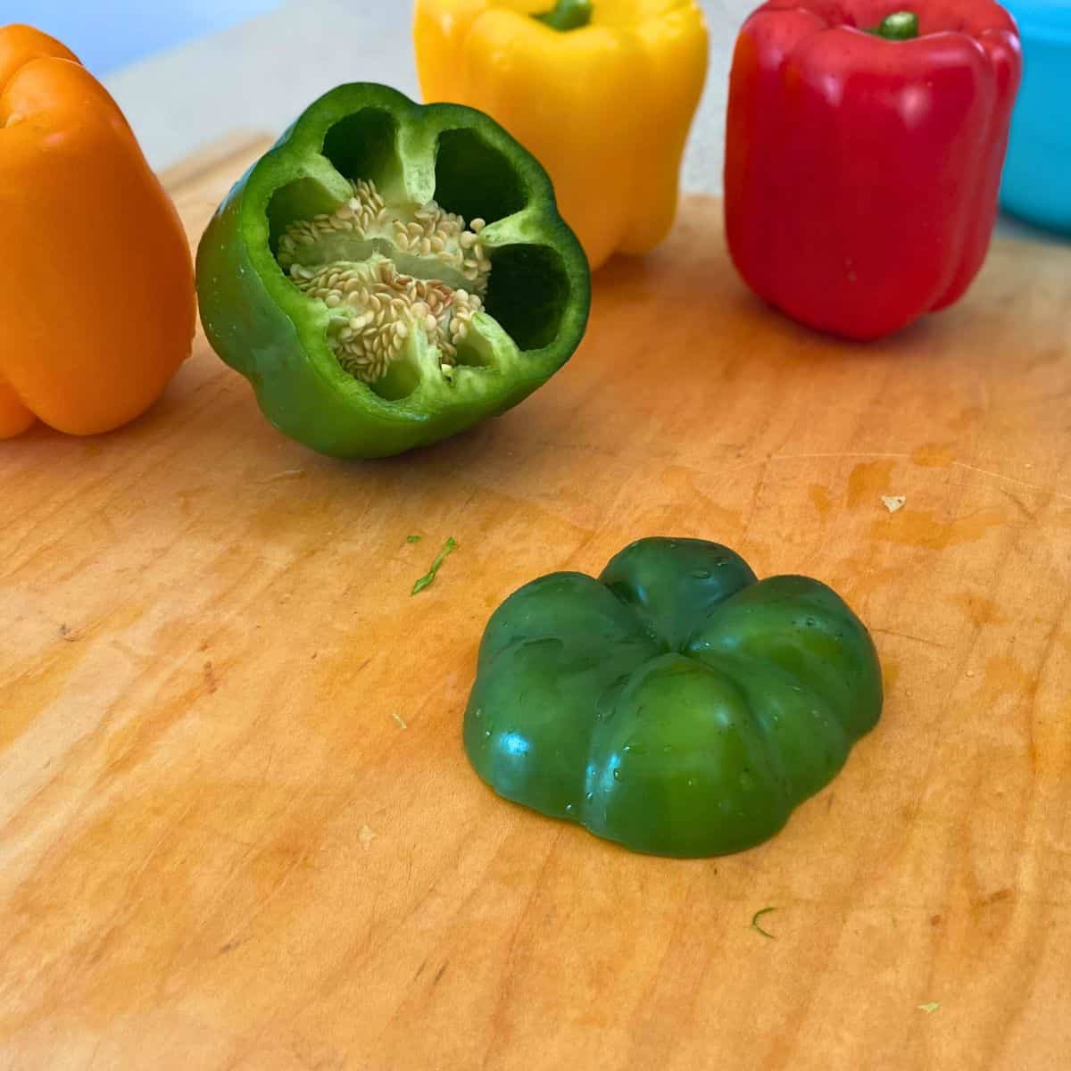 A green bell pepper with the bottom cut off and the seeds and membrane exposed.