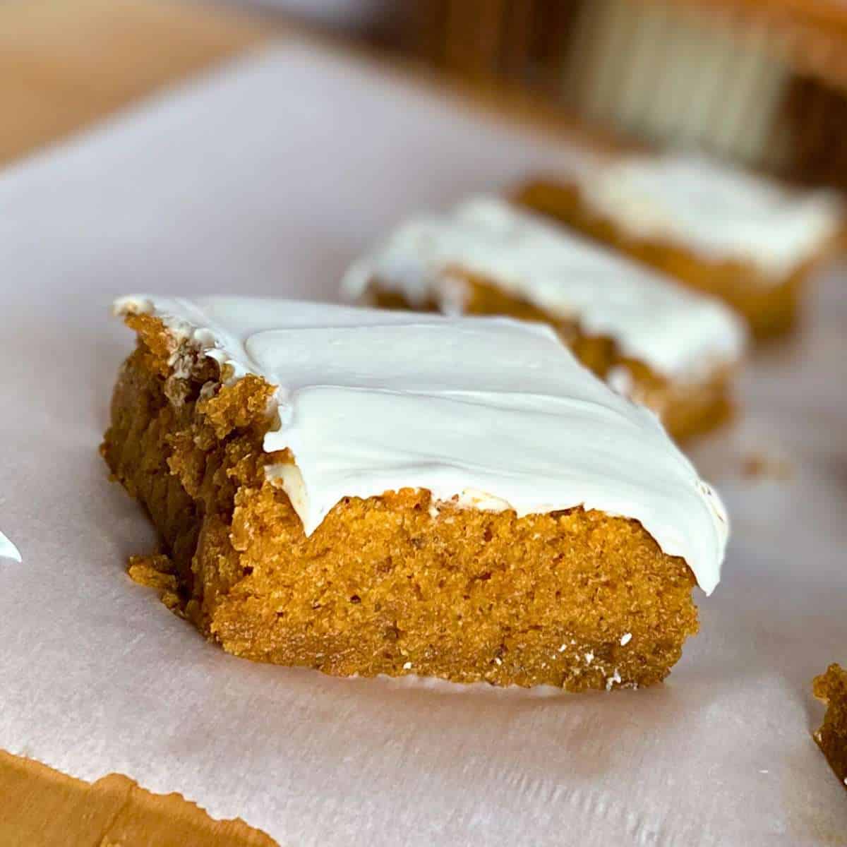 A gluten free pumpkin bar with white frosting.