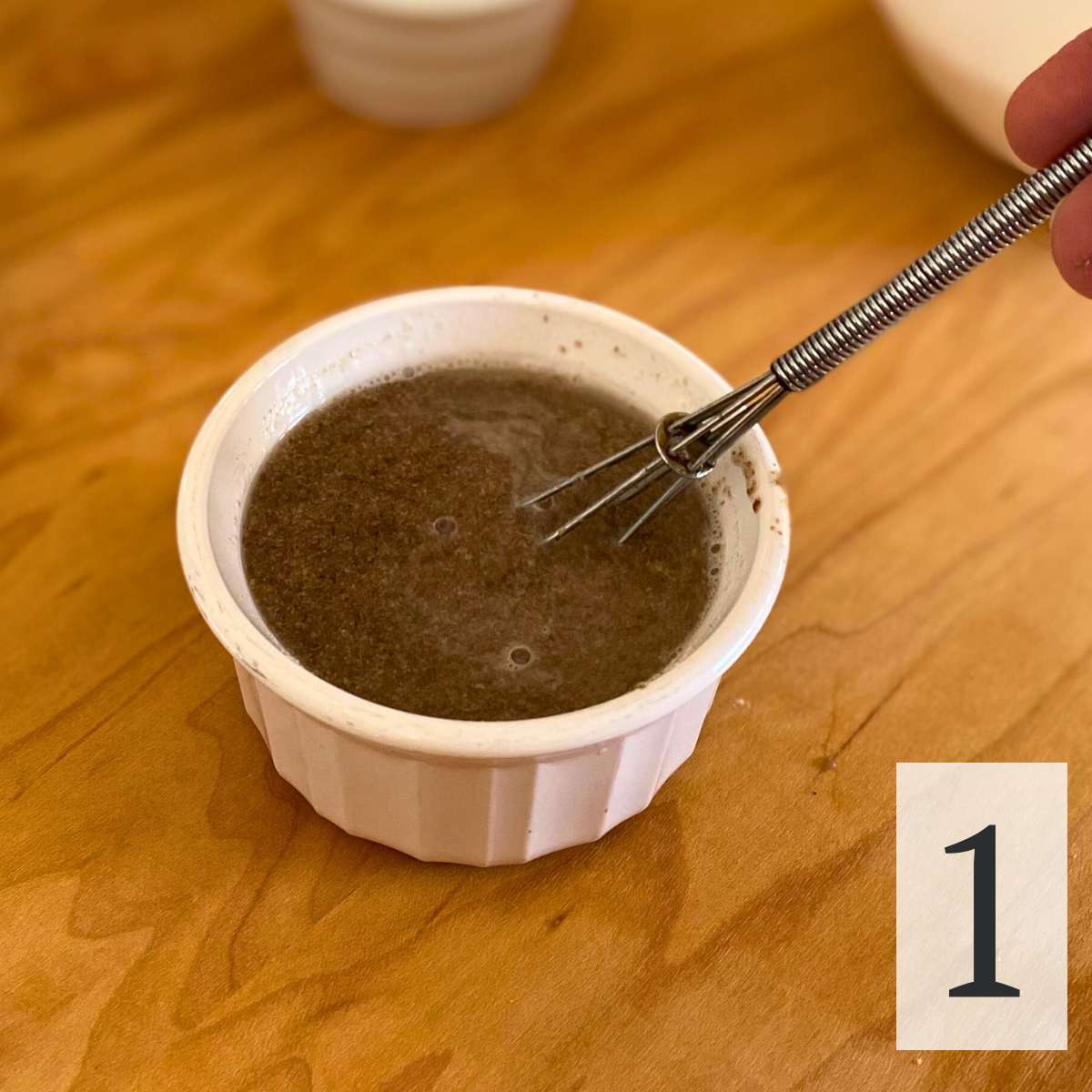 Ground flaxseed and water mixture in a small bowl with a whisk.
