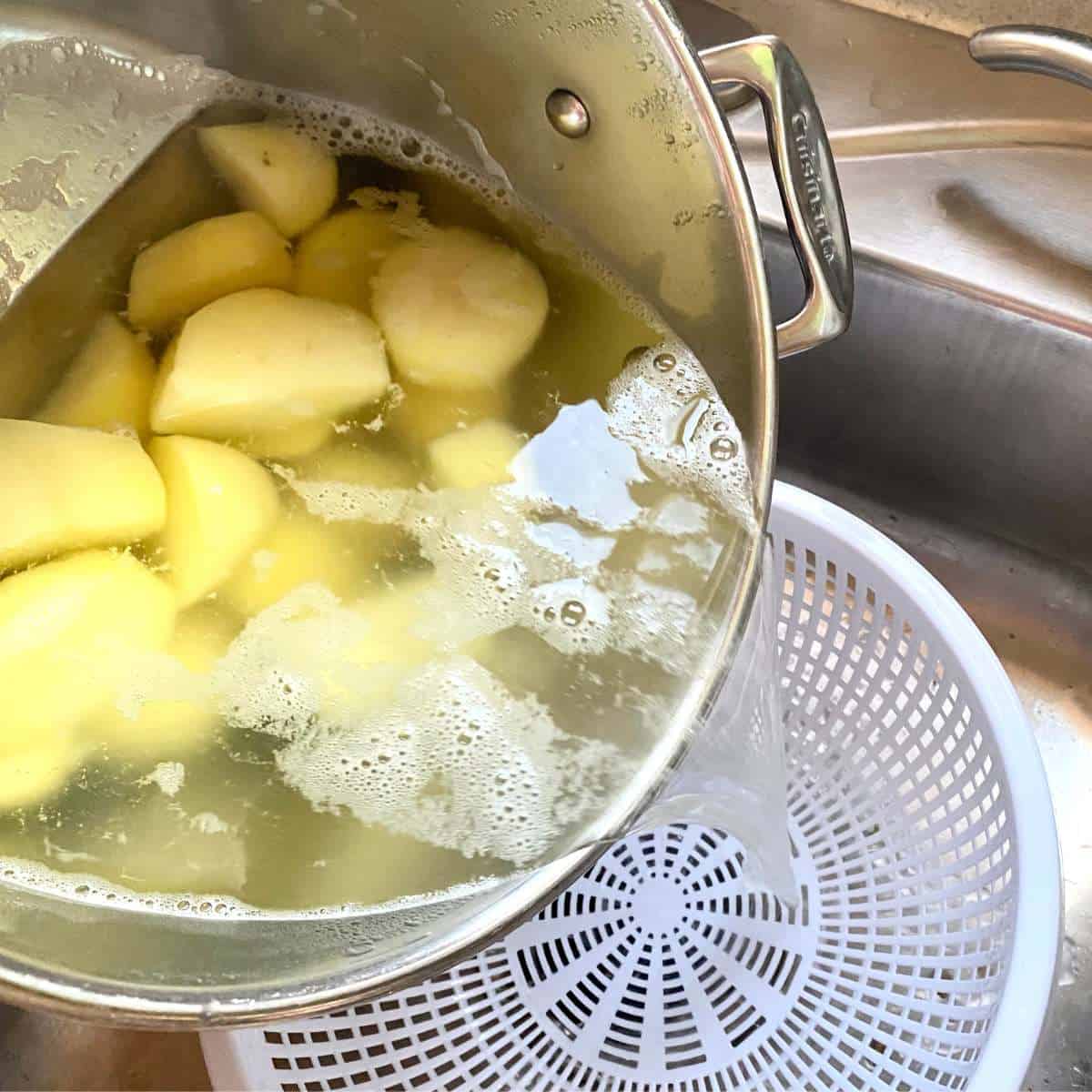 Water being poured out of a stockpot into a colander.