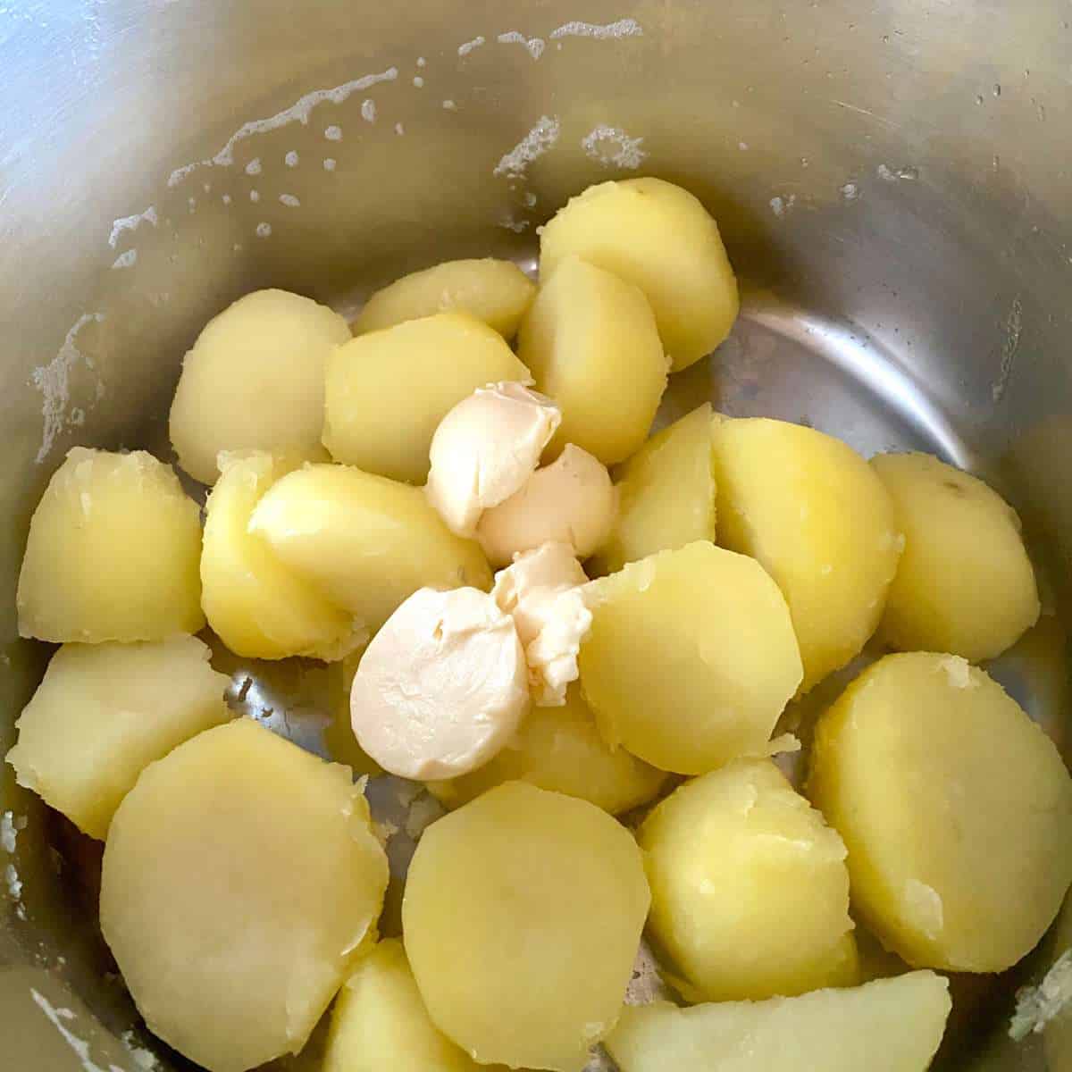 cooked potatoes in a pot with dairy free margarine.