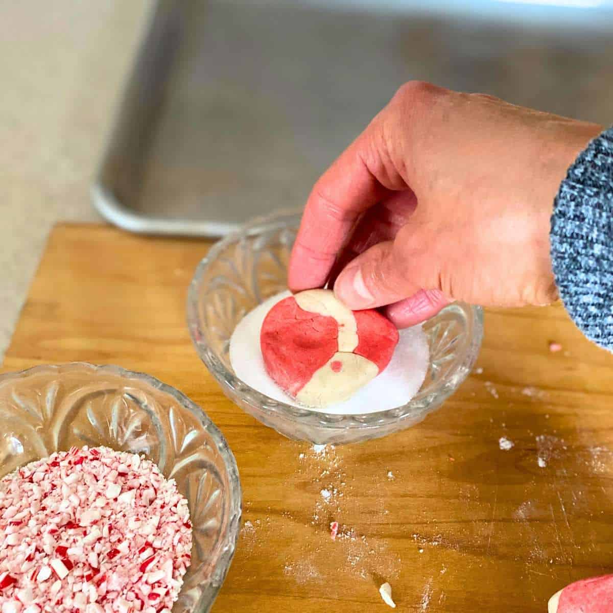 A cookie being dipped in sugar.