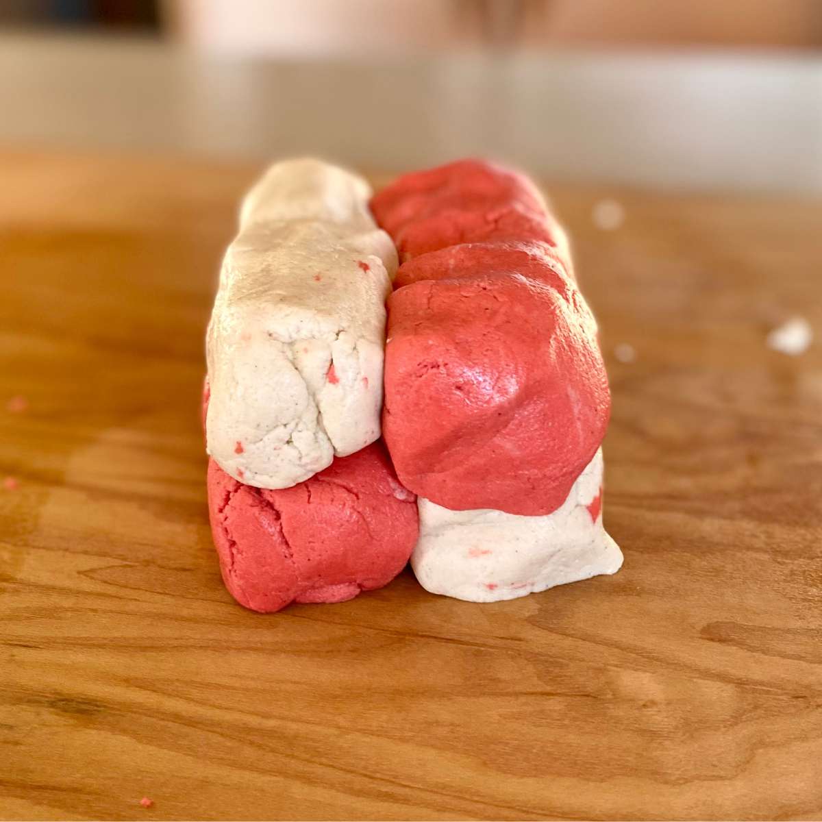 red and white dough logs stacked on top of each other to form a checkerboard pattern.